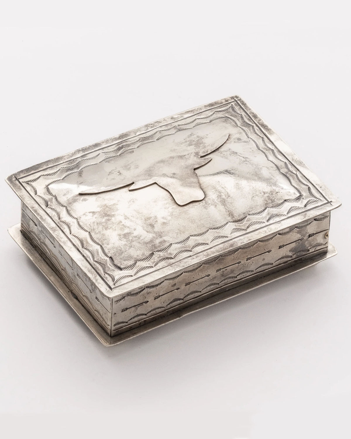 The J Alexander Rustic Silver 88-6 Silver Box w/ Longhorn features a rectangular rustic silver design with a raised longhorn head on the lid and decorative edging, making it perfect for Southwestern home decor. Shown against a plain white background.