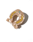 Beige marbled horseshoe hair clip with yellow glitter, blue dots, and stars by Faire, made from biodegradable acetate.