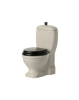 The Maileg Toilet by Maileg is a small beige toy toilet with a black seat and lid, designed for toy mice. With its classic round bowl and water tank, it’s perfect for imaginative play, shown isolated on a white background.