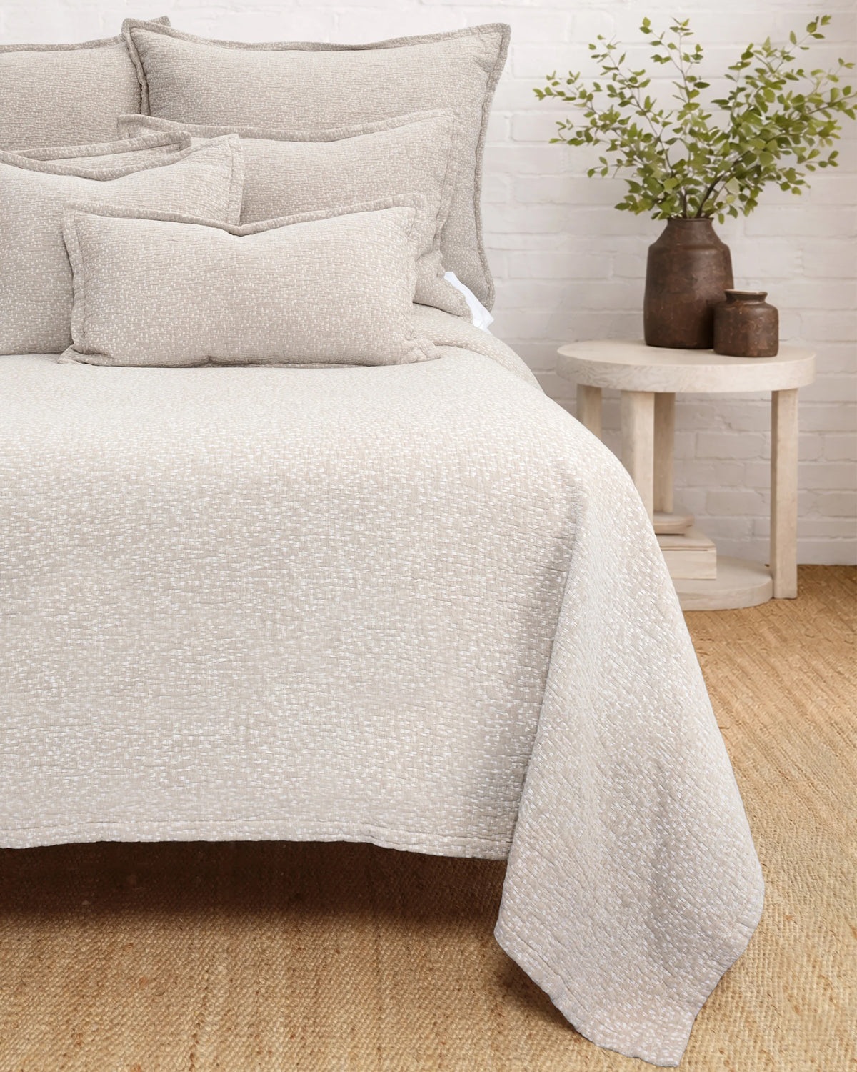 Malibu Matelasse Queen bedding by Pom Pom with coordinating pillows, styled with vases and greenery for a fresh look.