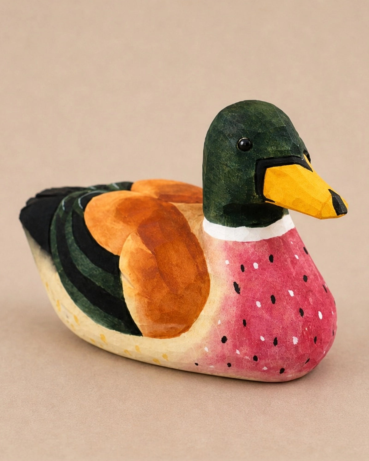 Green hand-painted carved basswood duck with yellow beak, rustic decor by Faire for Bungalow Furniture & Accessories.