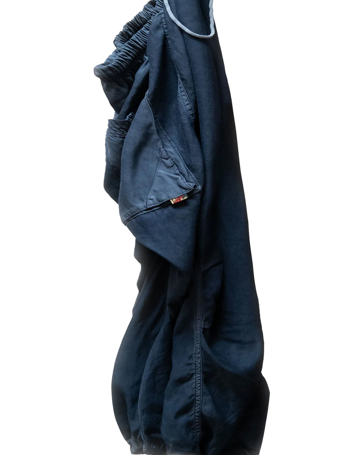 The Free City (sparrow, LLC) Matte/Satin Biggy Pant is a pair of dark blue, oversized loose pants with a drawcord and elastic waistband, plus visible pocket detail, shown against a white background.