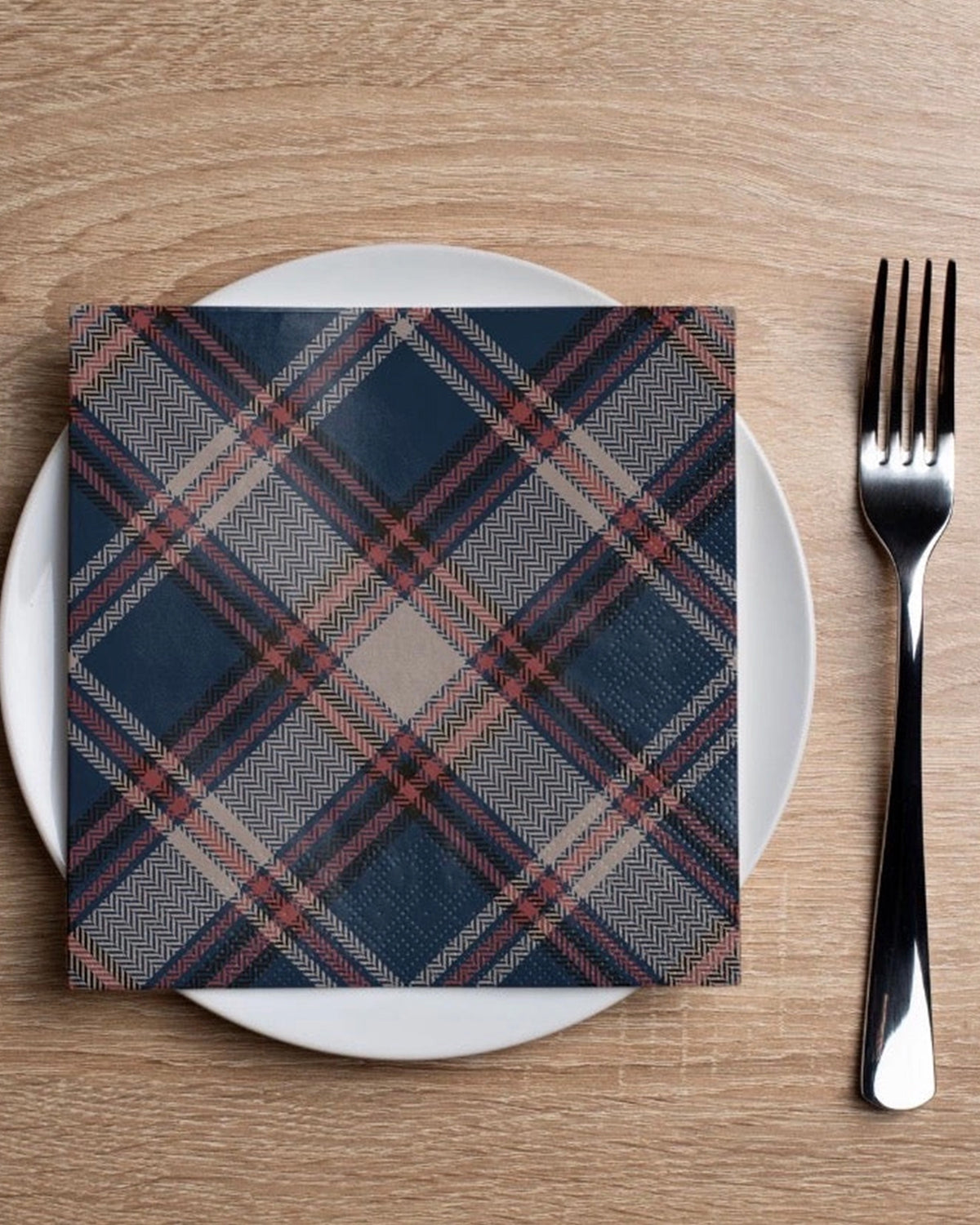 Faire navy plaid cocktail napkin on a white plate with fork, Bungalow Furniture, blue checkered cotton, tabletop setting.