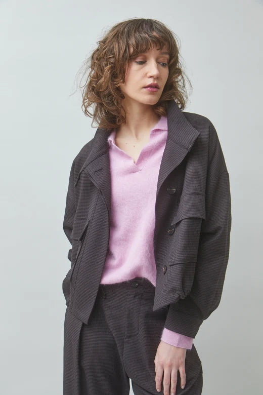 Pink sweater layered with oversized brown jacket and matching pants from SUNCOO, styled in a simple studio setting.