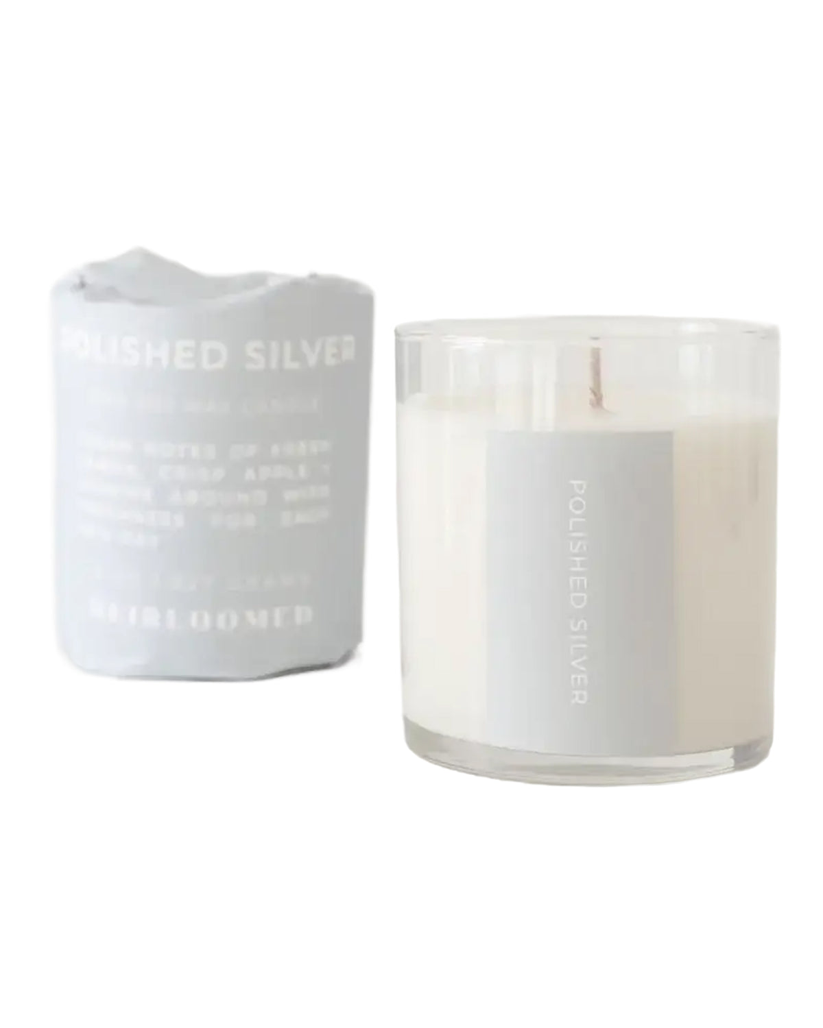 The Faire Polished Silver Candle, hand-poured soy wax in a clear glass jar, is shown next to its packaging against a white background. Enjoy its custom blended fragrance and clean burn for a refined atmosphere.