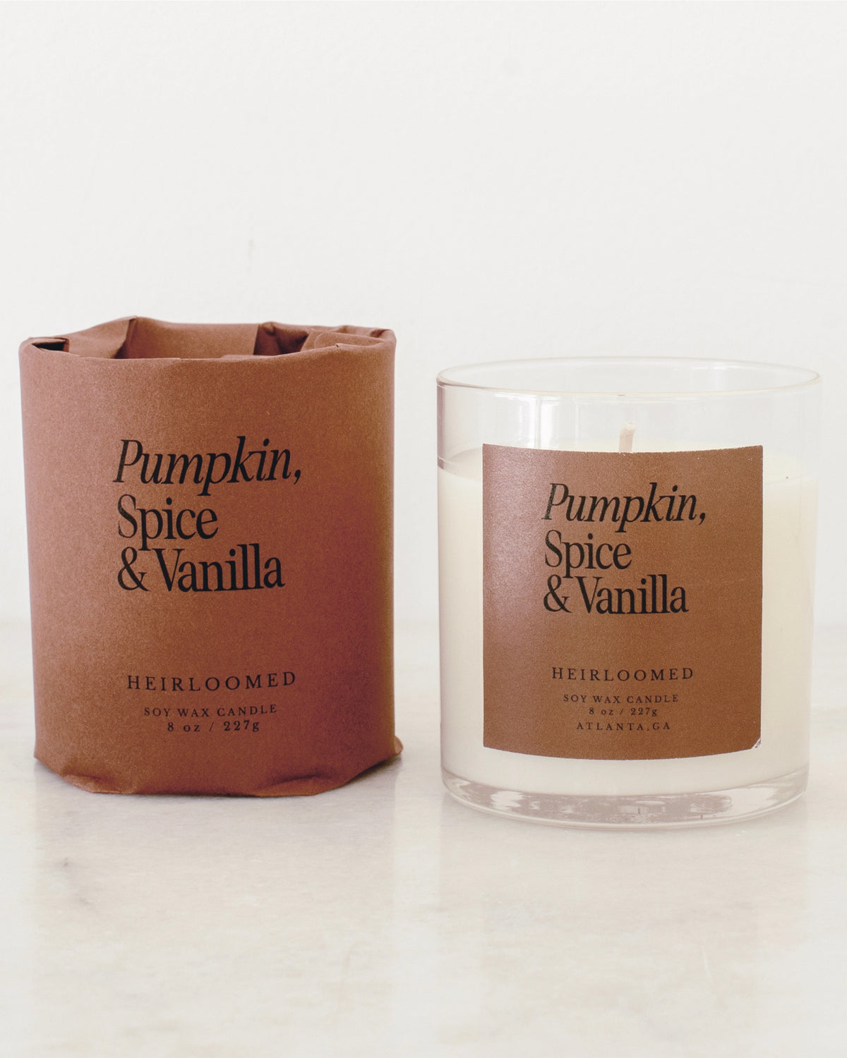 Pumpkin, Spice &amp; Vanilla candle in a glass jar with a matching fall sleeve by Bungalow Furniture &amp; Accessories.