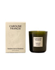 Random Acts of Kindness 7.5oz sandalwood candle in a green jar next to its beige box with an embossed bird.