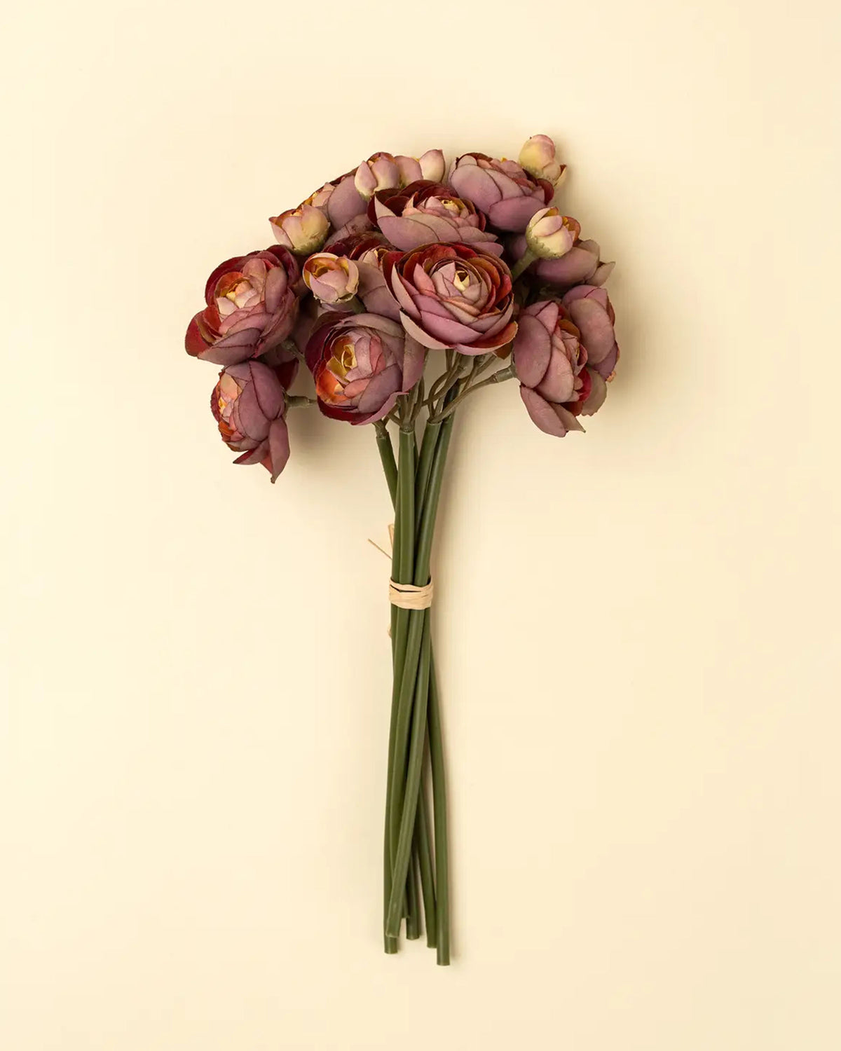 The Faire Ranunculus Bouquet features deep burgundy faux flowers with green stems, tied with light tan string and set against a beige background—ideal for displaying in your favorite decorative vase.
