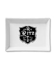 The Faire Ceramic Tray is a rectangular white organizer with a vintage-style "Paris Ritz Hotel" emblem and floral accents—ideal as a jewelry holder or trinket tray gift.