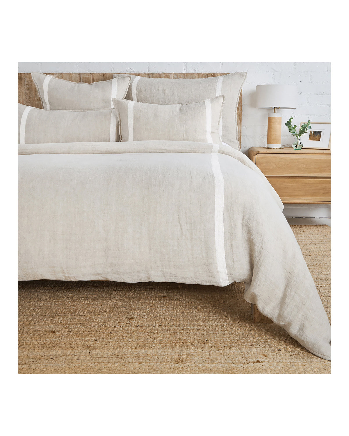 Beige linen King duvet with white herringbone stripes by POM POM, styled beside a nightstand in a serene bedroom.