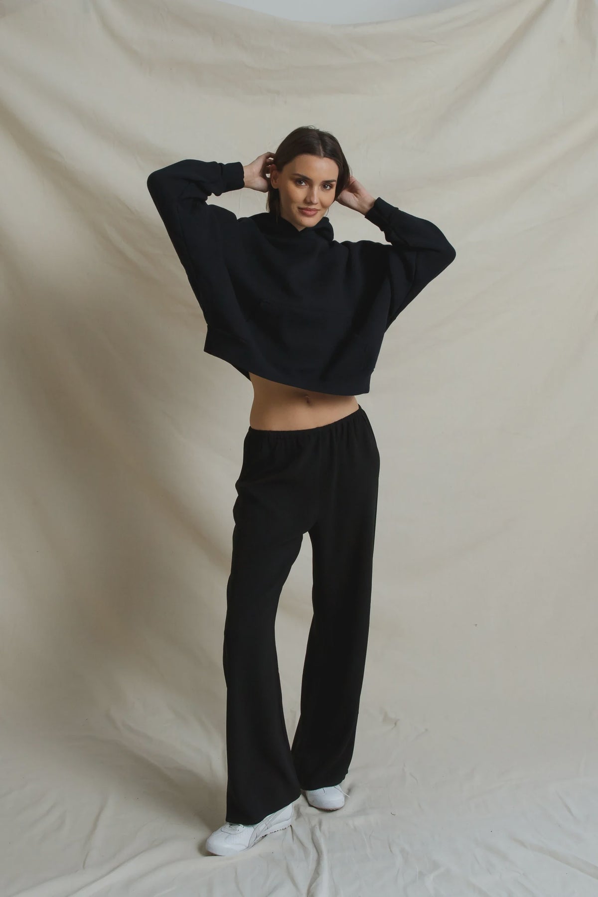 Black cropped hoodie and Georgia Crepe Pant styled with white sneakers.