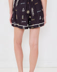 Sea New York Juliet Shorts in relaxed fit with colorful embroidery, styled with black shoes, white wall backdrop.