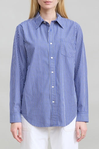 Denimist blue and white striped boyfriend shirt with white pants, styled against a simple neutral background.