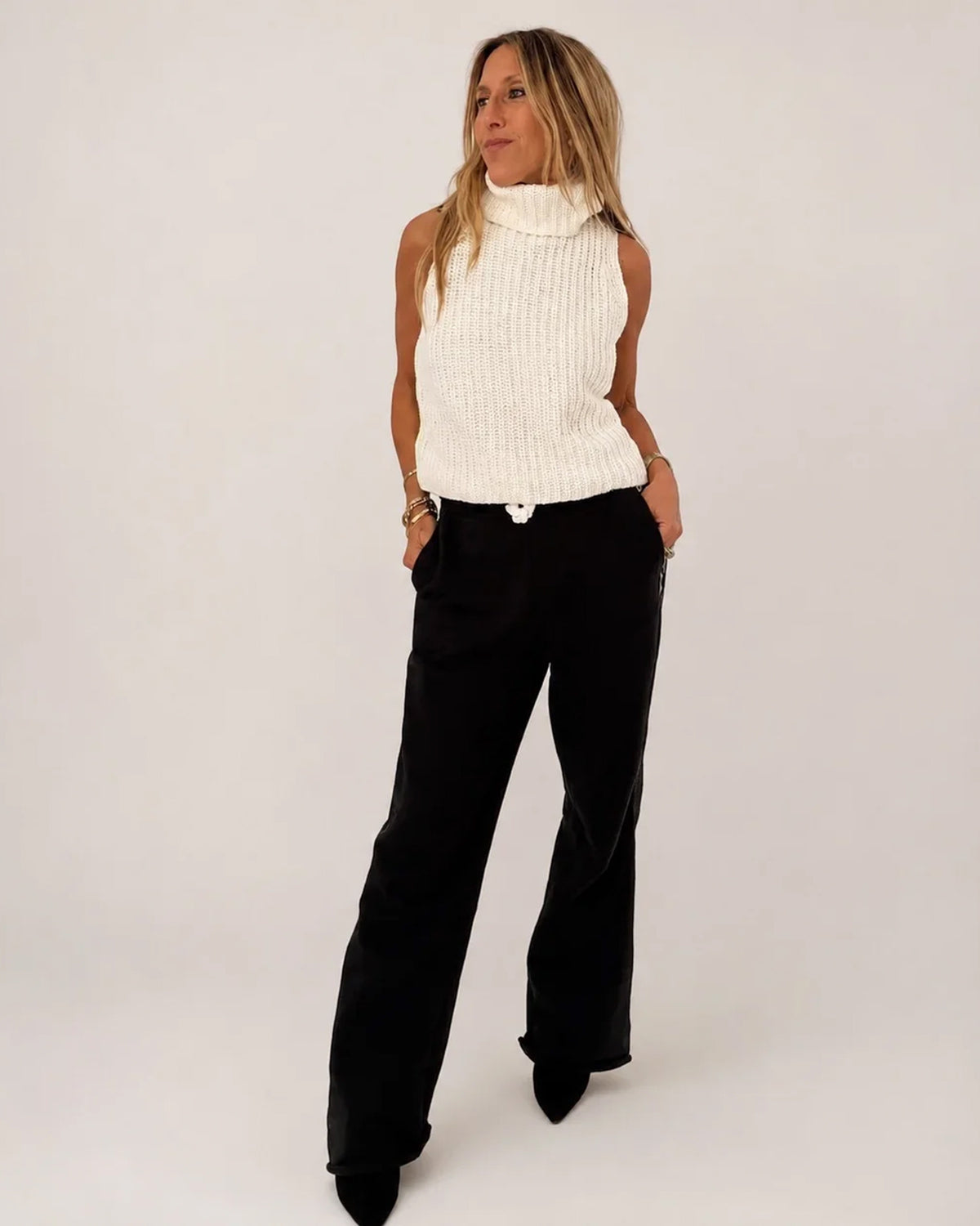 Shelly Sweater by Kerri Rosenthal in a casual look, paired with black pants, hands in pockets.
