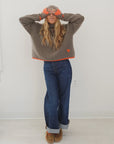 Brown rib-knit turtleneck by Kerri Rosenthal, featuring a wool-cashmere blend with orange trim and heart detail.