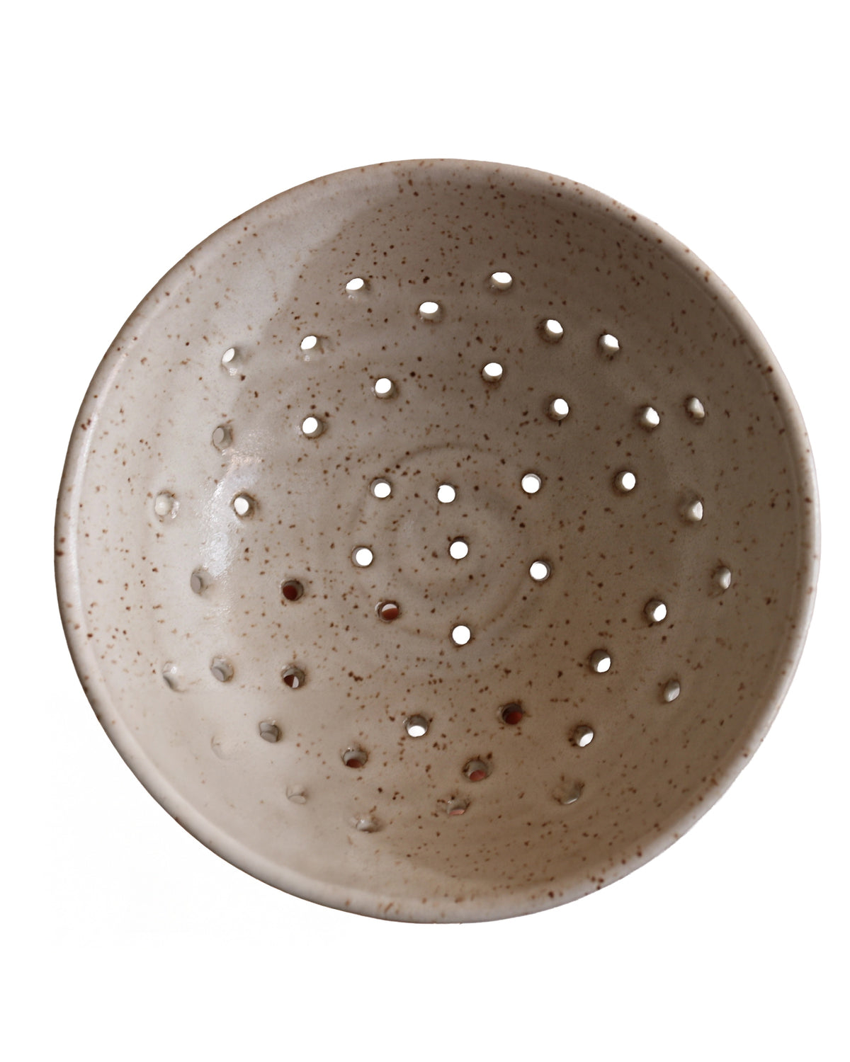 The KJ Berry Bowl by Faire is a round beige ceramic bowl with brown speckles and evenly spaced holes throughout, resembling a colander. Shown on a white background.