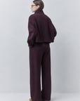 Maroon Jio jacket with wide-leg pants by SUNCOO, model stands facing away against a plain backdrop.
