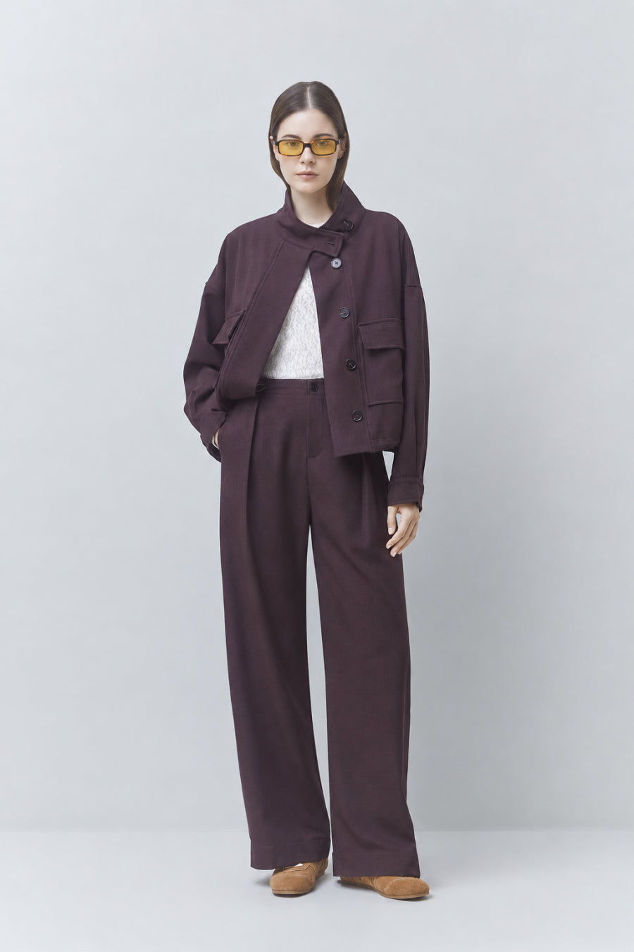 Plum pantsuit by SUNCOO with white top and yellow sunglasses, styled for a modern, colorful lifestyle look.