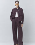 Plum pantsuit by SUNCOO with white top and yellow sunglasses, styled for a modern, colorful lifestyle look.