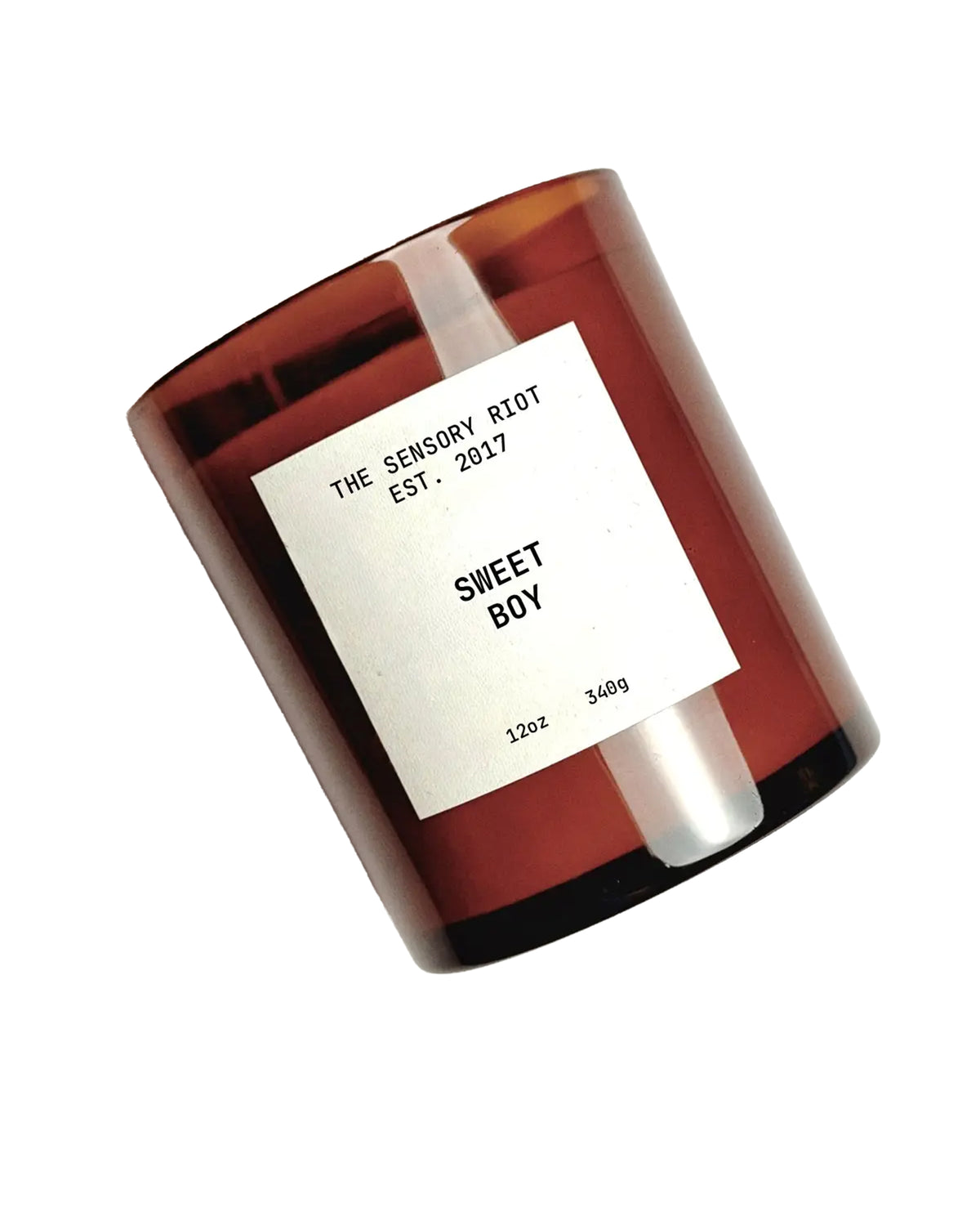 A brown 12 oz SWEET BOY soy wax candle by Faire sits tilted against a white background. The jar features a white rectangular label and offers clean-burning, non-toxic fragrance.