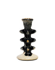The Creative Co-op Terra-Cotta Taper Holder features a creamy white ceramic base with a glossy black, textured stem adorned with wavy ridges and a slim candle opening at the top, blending style and function.