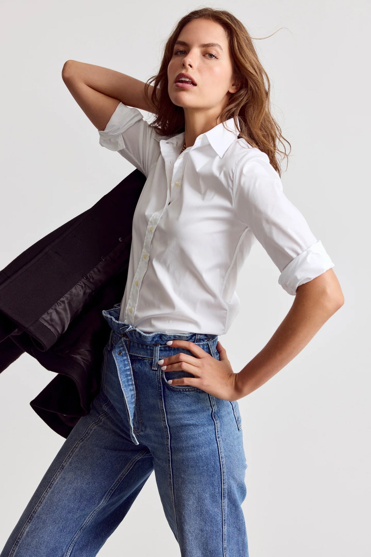 THE SHIRT 3/4 Sleeve Essentials Icon Shirt styled with jeans, black jacket draped over shoulder, casual chic look.