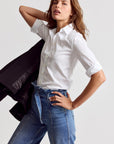 THE SHIRT 3/4 Sleeve Essentials Icon Shirt styled with jeans, black jacket draped over shoulder, casual chic look.
