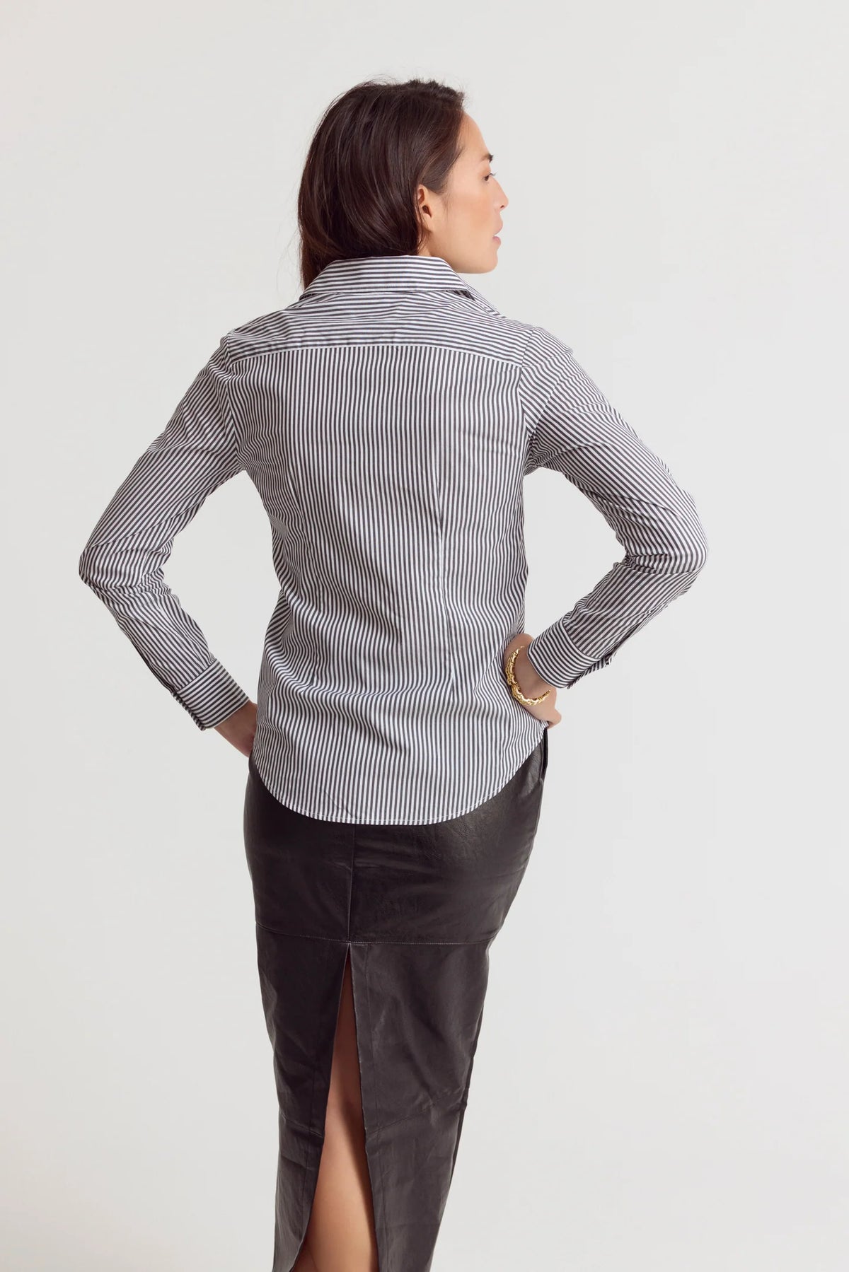 Striped Icon Shirt by THE SHIRT with no-gape buttons, styled with a black skirt, modern and polished look.