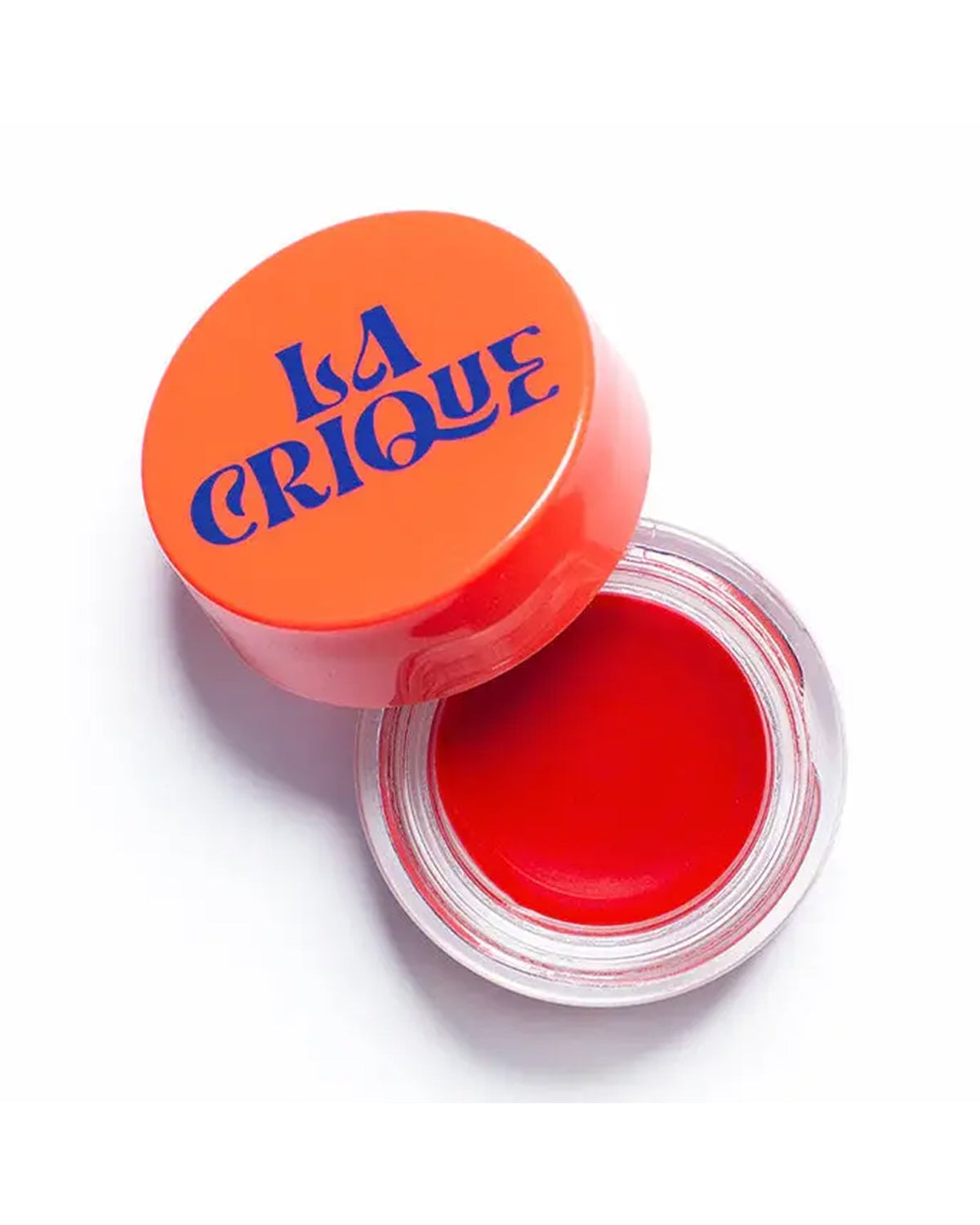 An open container of Faire 03 Tinted Lip Balm & Blush with a bright red tint and an orange lid is viewed from above on a white background.