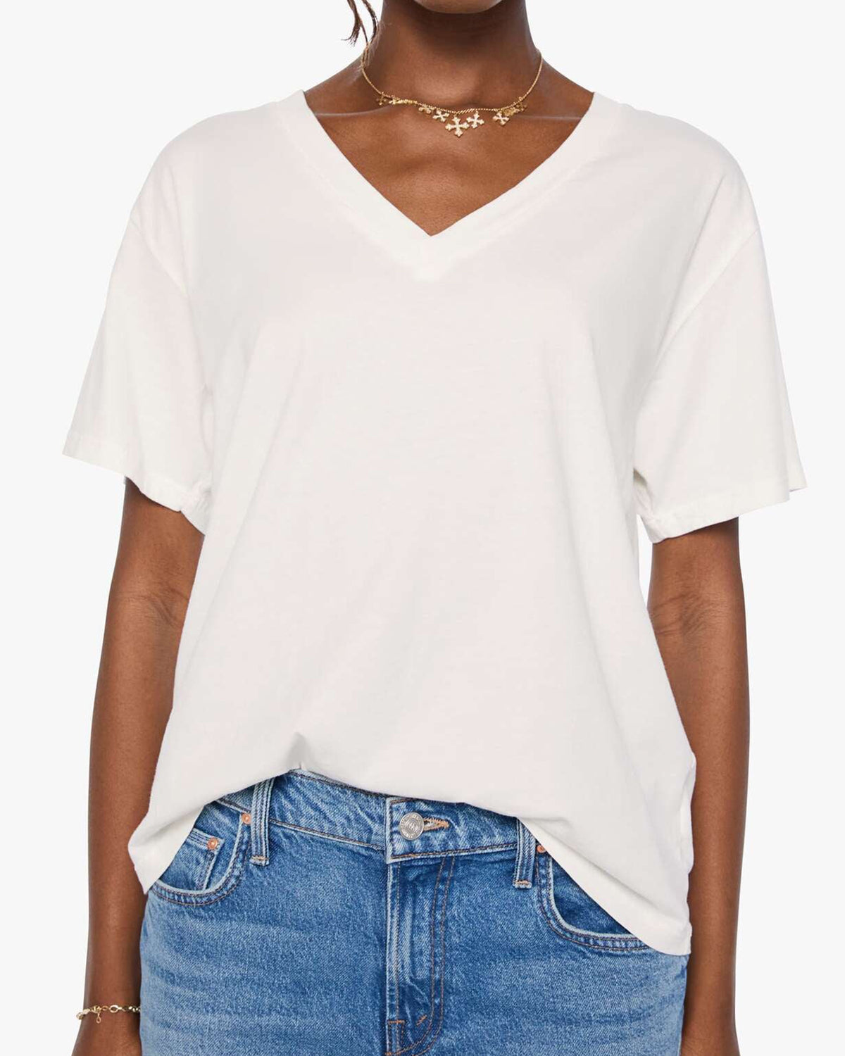 Boxy Supima cotton V-neck tee in blue by Mother, styled with jeans, hands in pockets, casual modern look.
