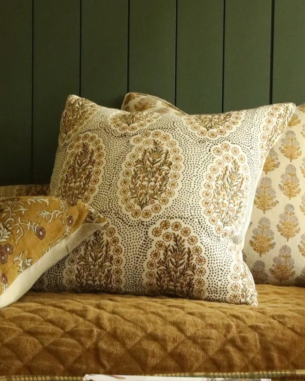 Olive Mustard pillow by Filling Spaces on a mustard quilted bed with earth-tone accents, styled for a cozy bedroom.