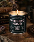 Faire Witching Hour Soy Candle lit beside books and dried florals for a cozy, moody Halloween setting by Bungalow Furniture.