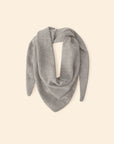 Le Petit Scarf—a light gray cashmere scarf with pointed ends, made in Los Angeles—is displayed in a loose triangular shape on a plain beige background.