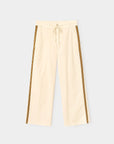Beige wide-leg cotton twill pants with brown side stripes, front pockets, and drawstring waist by Xirena.