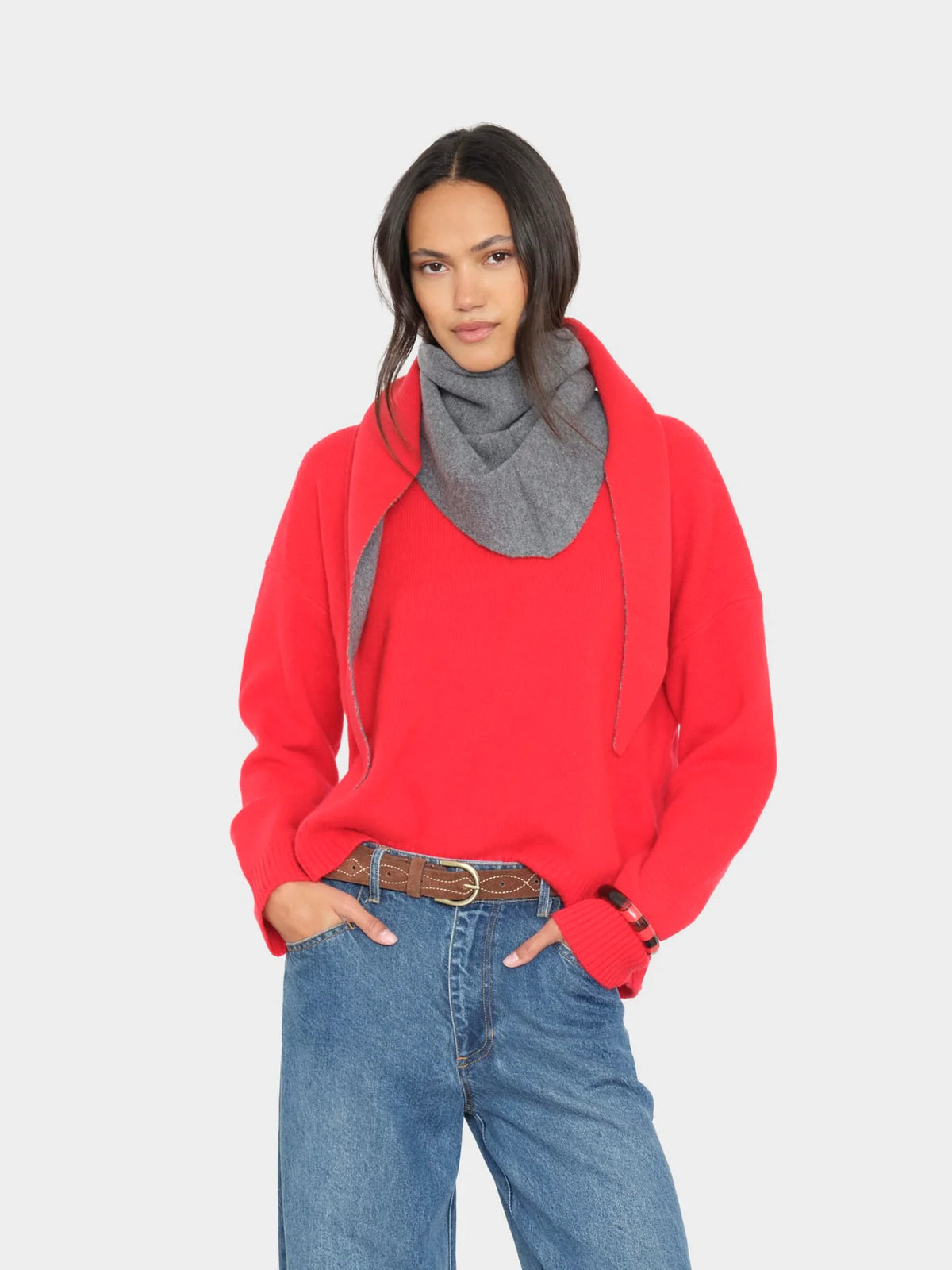 Le Petit Scarf in red, styled with a cozy sweater and jeans; modern casual look, neutral background.